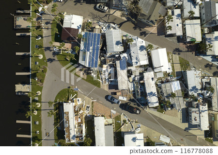 Hurricane strong wind destroyed suburban house roofs in Florida mobile home residential area. Consequences of natural disaster 116778088