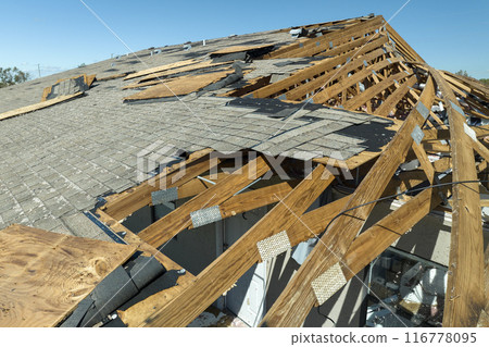 Hurricane Ian destroyed house roof in Florida residential area. Natural disaster and its consequences 116778095