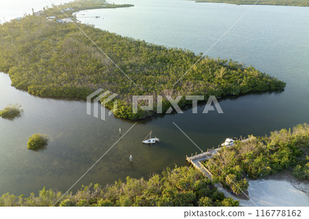 Half sunken sailing yacht capsized on shallow bay waters after hurricane Ian in Manasota, Florida 116778162