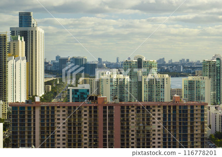 View from above of luxurious highrise hotels and condos on Atlantic ocean shore in Sunny Isles Beach city. American tourism infrastructure in southern Florida 116778201