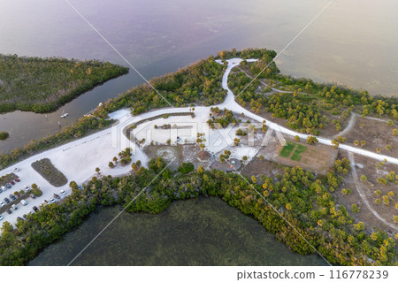 Vehicle parking area with cars parked on ocean beach parking lot at sunset. Summer vacation on beachfront in Southern Florida 116778239