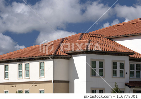 Tiled roof covering of condo building in Florida. Closeup of house rooftop covered with ceramic shingles 116778301