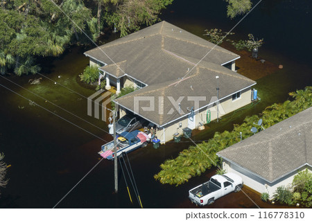 Surrounded by hurricane rainfall flood waters homes in Florida residential area. Aftermath of natural disaster 116778310