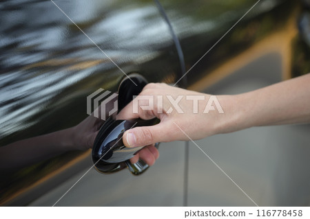 Closeup of driver hand opening car front door 116778458