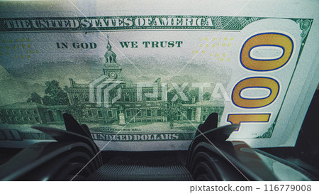 Close up of bill counter counting hundred dollar bills for currency exchange Close up of bill counter counting hundred dollar bills for currency exchange 116779008