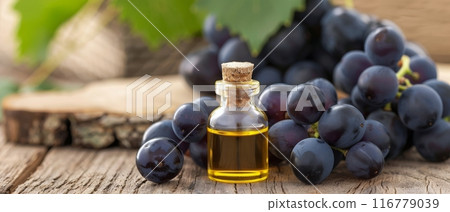 Grape Seed Oil and Grapes on Wooden Table 116779039