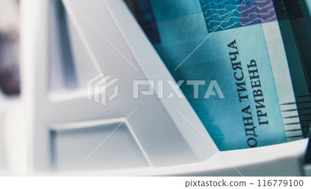 Close up of bill counter counting thousand of hryvna bank notes Close up of bill counter counting thousand of hryvna bank notes 116779100