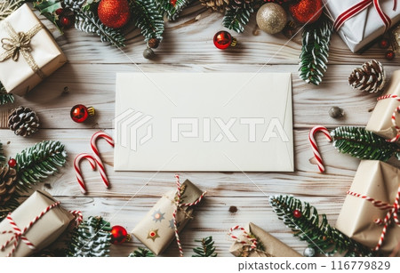 Blank letter surrounded by Christmas decorations, gifts, and candy canes on a wooden table 116779829