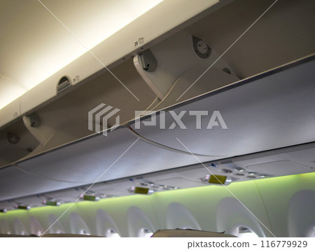 Upper part of aircraft cabin where bags are stored Perfect for travel and aviation content. Aircraft overhead storage area shown in detail. Capture convenience and functionality of aircraft design. Upper part of aircraft cabin where bags are stored Perfect for travel and aviation content. Aircraft overhead storage area shown in detail. Capture convenience and functionality of aircraft design. 116779929