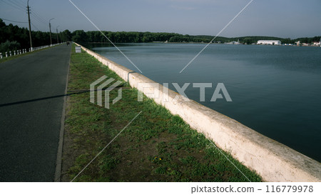 Embankment, curb, lawn, asphalt road. Diagonal lines 116779978