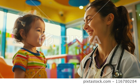 Pediatric doctor with a warm smile attending to a young child in a colorful clinic environment 116780284
