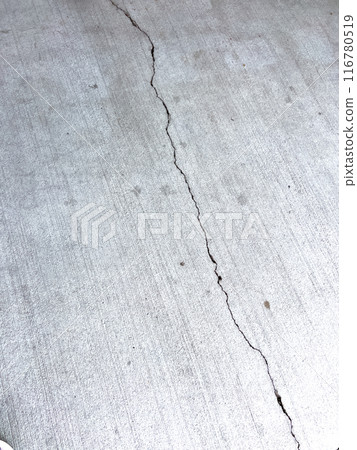 Close-up of a cracked concrete surface, showing distinct lines and fractures. The texture of the concrete is clearly visible, highlighting the wear and damage over time. This image captures the raw Close-up of a cracked concrete surface, showing distinct lines and fractures. The texture of the concrete is clearly visible, highlighting the wear and damage over time. This image captures the raw 116780519