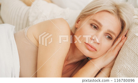 Bad morning. Female depression. Problem thinking. Upset woman laying in bed on pillow feeling sorrow confusion suffering from sadness at light home. Bad morning. Female depression. Problem thinking. Upset woman laying in bed on pillow feeling sorrow confusion suffering from sadness at light home. 116780896