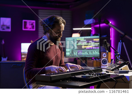 Musician playing electronic keyboard notes and recording tunes for mix and master session, using daw software interface to produce new music. Artist composing songs on piano midi controller. Musician playing electronic keyboard notes and recording tunes for mix and master session, using daw software interface to produce new music. Artist composing songs on piano midi controller. 116781461