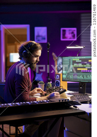 Sound engineer editing audio recordings with daw software and mixing console, adjusting volume levels on amplifier. Artist mixing and mastering soundtracks, operating pre amp knobs. 116781469