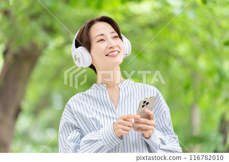 戴著耳機聽音樂的女人，鮮綠色 116782010