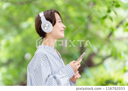 戴著耳機聽音樂的女人，鮮綠色 116782033