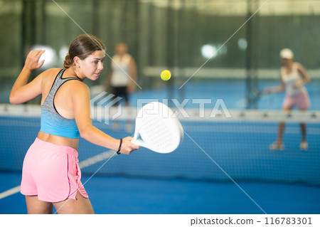 Portrait of girl paddle tennis player during friendly doubles couple match at court 116783301