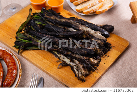 Catalan festive grilled calcots with butifarra sausage and romesco sauce 116783302