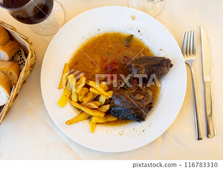 Plate of delicious meat dish - stewed beef cheeks with gravy and potatoes closeup Plate of delicious meat dish - stewed beef cheeks with gravy and potatoes closeup 116783310