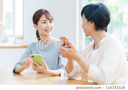 一家人在餐廳看智慧型手機 116783326