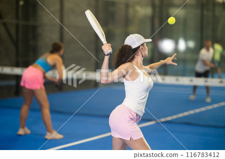 Two women playing tennis against man 116783412