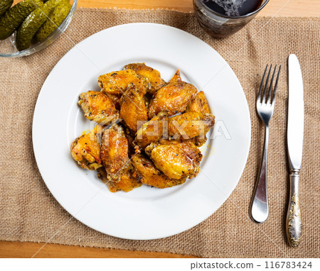 Alitas de pollo con patata, chicken wings with potato on a ceramic plate in restaurant Alitas de pollo con patata, chicken wings with potato on a ceramic plate in restaurant 116783424
