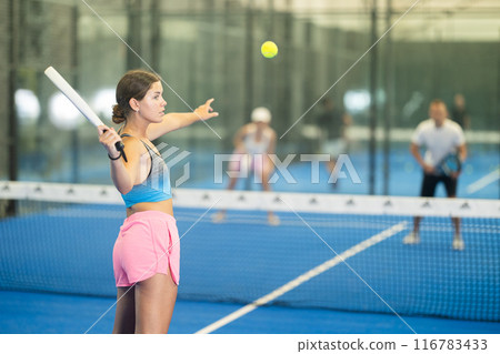 Padel game - girl with partners plays on tennis court Padel game - girl with partners plays on tennis court 116783433