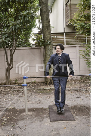 Man leaning on iron bar outdoors Man leaning on iron bar outdoors 116783524