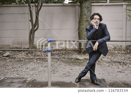 一個男人靠在戶外的單槓上 116783534