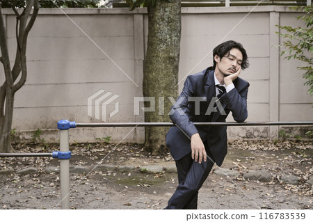 Man leaning on iron bar outdoors 116783539