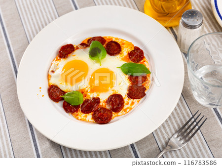 Sunny Side glaze with chorizo slices and basil 116783586