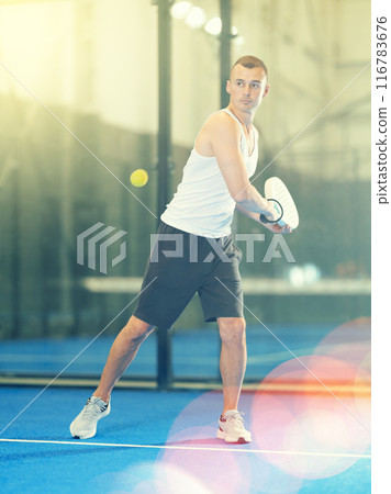 Young man making serve while playing tennis 116783676