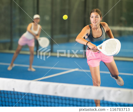 Portrait of girl paddle tennis player during friendly doubles couple match at court 116783713