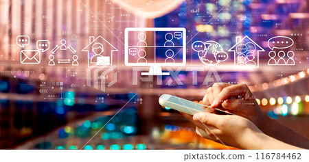 Online meeting theme with person using a smartphone in city at night Online meeting theme with person using a smartphone in city at night 116784462