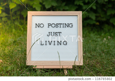 NO POSTING JUST LIVING text on letter board on background of greenery garden. Concept of social media technology detox. Farmcore nature core slow life NO POSTING JUST LIVING text on letter board on background of greenery garden. Concept of social media technology detox. Farmcore nature core slow life 116785802
