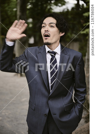 一個在戶外穿著富有表現力的西裝的男人 116786084