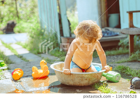 A little boy is bathing in a basin 116786528
