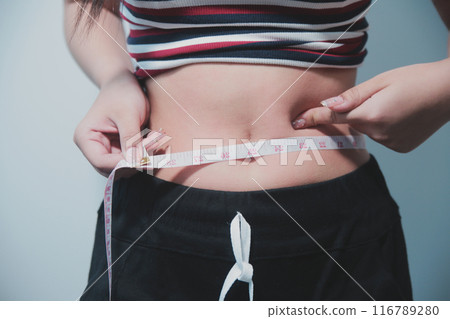 Women body fat belly. Obese woman hand holding excessive belly fat. diet lifestyle concept to reduce belly and shape up healthy stomach muscle. 116789280