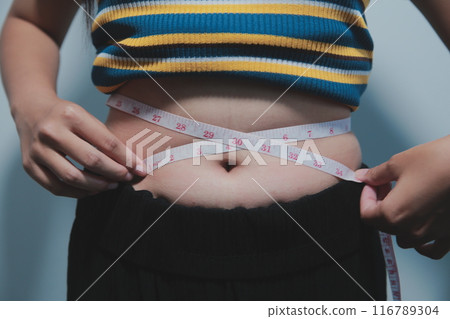Women body fat belly. Obese woman hand holding excessive belly fat. diet lifestyle concept to reduce belly and shape up healthy stomach muscle. Women body fat belly. Obese woman hand holding excessive belly fat. diet lifestyle concept to reduce belly and shape up healthy stomach muscle. 116789304
