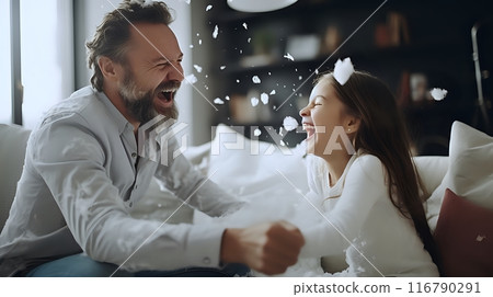 A father and daughter having a pillow fight 116790291