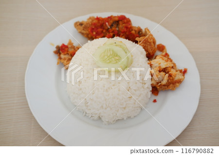 Ayam geprek is a typical Indonesian dish of fried chicken with flour that is mashed or mashed with plow chili sauce. 116790882