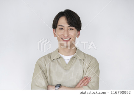 一名20多歲的男子抱著雙臂微笑著看著鏡頭 一名20多歲的男子抱著雙臂微笑著看著鏡頭 116790992