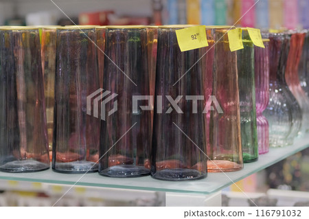 Colored glassware are sold in shop. Jars for bouquets of flowers. 116791032