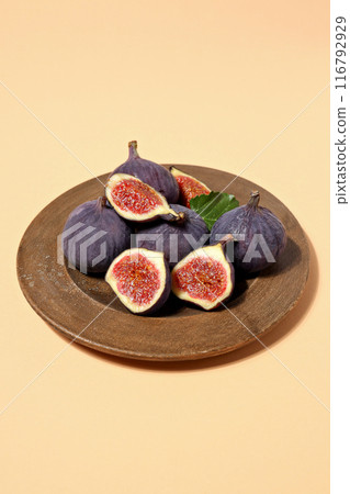 Fresh ripe figs in a wooden bowl on a light background 116792929