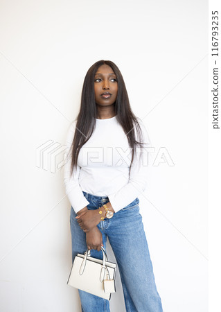 Stylish woman holds a designer handbag, dressed in casual wear with an elegant touch Stylish woman holds a designer handbag, dressed in casual wear with an elegant touch 116793235