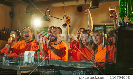 Football enthusiasts shouting of joy and happiness, celebrate at bar, raising their beers and cheering, victory of favorite sport team. Football enthusiasts shouting of joy and happiness, celebrate at bar, raising their beers and cheering, victory of favorite sport team. 116794098