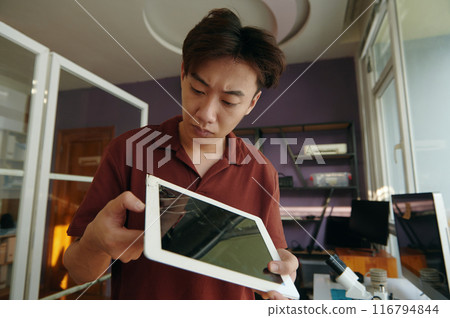 Repairman Examining Broken Screen Of Tablet 116794844