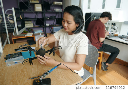Woman Repairing Broken Drone In Workshop 116794912