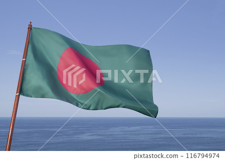 A green and red flag of Bangladesh flag is flying in the air 116794974